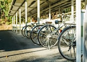 Thumbnail 1 of 7 - A row of bicycles are parked in a bike rack.