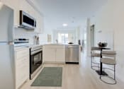 Thumbnail 4 of 8 - A modern kitchen with white cabinets and stainless steel appliances.at Sylk Towers, Ontario