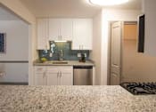 Thumbnail 2 of 23 - A kitchen with white cabinets and a granite countertop. at Paces Ridge at Vinings, Atlanta, Georgia