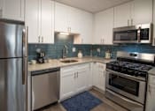 Thumbnail 1 of 23 - A modern kitchen with a stainless steel refrigerator, microwave, oven, and sink. at Paces Ridge at Vinings, Atlanta