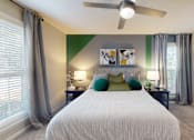 Thumbnail 6 of 33 - A bedroom with a large bed and a ceiling fan.