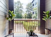 Thumbnail 10 of 23 - A balcony with a table and two potted plants at Embry Hills, Atlanta, 30042