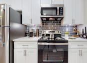 Thumbnail 1 of 23 - A kitchen with a stove, refrigerator, and microwave at Embry Hills, Atlanta, 30042