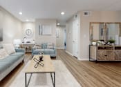 Thumbnail 3 of 26 - A living room with a blue couch and a wooden coffee table.