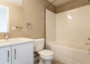 Thumbnail 60 of 72 - A white toilet sits next to a white bathtub in a bathroom.