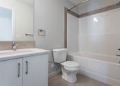 Thumbnail 56 of 72 - A white toilet sits next to a sink in a bathroom.