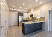 Thumbnail 69 of 72 - A modern kitchen with a dark wood finish and stainless steel appliances.