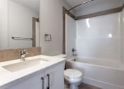 Thumbnail 67 of 72 - A white toilet sits next to a sink in a bathroom.