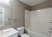Thumbnail 61 of 72 - A white toilet sits next to a white sink in a bathroom.