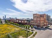 Thumbnail 45 of 72 - A large red brick building sits in the middle of a city street.