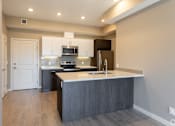 Thumbnail 55 of 72 - A modern kitchen with a dark wood floor and white walls.