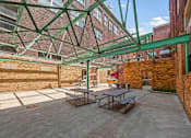 Thumbnail 25 of 29 - A patio with a table and chairs under a green canopy.