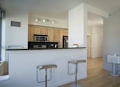 Thumbnail 15 of 29 - A kitchen with a white counter and bar stools.at 66 Main, Yonkers, 10701