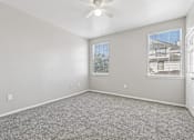 Thumbnail 10 of 17 - A room with a ceiling fan and two windows.