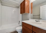 Thumbnail 11 of 17 - A white bathroom with a toilet, sink, and bathtub.