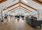 Thumbnail 12 of 17 - A spacious living room with a grey couch and wooden floors.