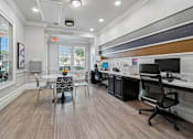 Thumbnail 14 of 17 - A modern office space with wood flooring and a variety of chairs and desks.