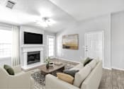 Thumbnail 2 of 17 - A living room with a fireplace, a television, and a painting.
