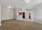 Thumbnail 8 of 17 - A spacious living room with wood flooring and a ceiling fan.