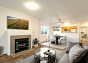 Thumbnail 16 of 19 - A living room with a fireplace and a painting on the wall.