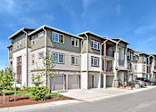 Thumbnail 1 of 18 - A row of modern townhouses with a clear blue sky above. at Mill Creek Meadows Apartments, Washington