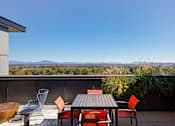 Thumbnail 18 of 43 - A patio with a table and chairs overlooking a mountainous landscape. at Riverfront Everett, Everett, 98201