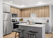 Thumbnail 1 of 43 - A modern kitchen with a large island and stools. at Riverfront Everett, Washington, 98201