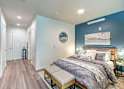 Thumbnail 15 of 43 - A bedroom with a bed, bench, and a painting on the wall. at Ravello Apartments, Washington