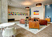 Thumbnail 5 of 43 - A living room with a white chair and a brown leather couch. at Ravello Apartments, Redmond