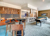 Thumbnail 1 of 43 - A modern room with a blue carpet and a wooden table. at Ravello Apartments, Redmond, Washington