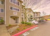 Thumbnail 7 of 19 - A parking lot in front of apartment building with a red curb and a sign  at Valley Springs Apartments, Renton, Washington