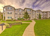Thumbnail 1 of 19 - Apartment complex with a walkway in front at Valley Springs Apartments, Washington, 98058