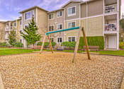 Thumbnail 8 of 19 - A playground with a slide in front of apartment buildings. at Valley Springs Apartments, Renton, WA, 98058