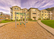 Thumbnail 5 of 19 - A playground with a swing set in front of apartment buildings at Valley Springs Apartments, Renton, WA