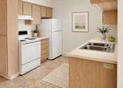 Thumbnail 13 of 14 - A kitchen with a white refrigerator, a white stove, and a white dishwasher.