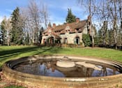 Thumbnail 28 of 30 - A large house with a pond in front of it.