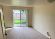Thumbnail 11 of 16 - A room with a carpeted floor and a sliding glass door.