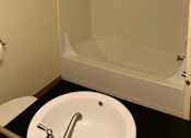 Thumbnail 15 of 16 - A white sink with a chrome faucet in a small bathroom.