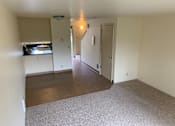 Thumbnail 10 of 16 - A room with a carpeted floor and a door leading to another room.