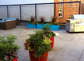 Thumbnail 14 of 30 - A patio with a black fence and red planters.