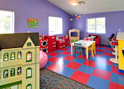 Thumbnail 20 of 30 - A playroom with a slide, a play kitchen, and a play dining room.