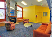 Thumbnail 17 of 30 - A yellow room with a stone fireplace and a red chair.