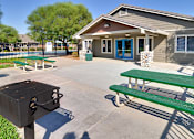 Thumbnail 3 of 30 - A green bench is in front of a building with a blue door.