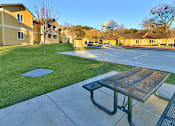 Thumbnail 9 of 41 - A basketball court with a hoop and a bench in the foreground.