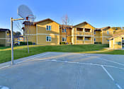 Thumbnail 5 of 41 - A basketball court is located in front of apartment buildings.