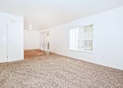 Thumbnail 13 of 30 - A room with a carpeted floor and a door on the left.