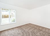 Thumbnail 22 of 30 - A room with a carpeted floor and a window.