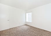 Thumbnail 23 of 30 - A room with a carpeted floor and a window with blinds.