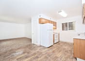 Thumbnail 26 of 30 - A kitchen with white appliances and wooden floors.