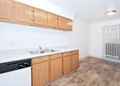 Thumbnail 24 of 30 - A kitchen with wooden cabinets and a black dishwasher.